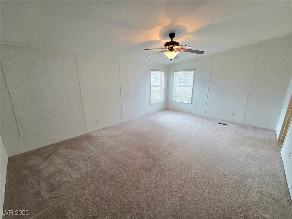 3290 Medicine Man Road Pahrump, NV 89048 - Photo 13 of 27 Carpeted spare room with a decorative wall and a ceiling fan