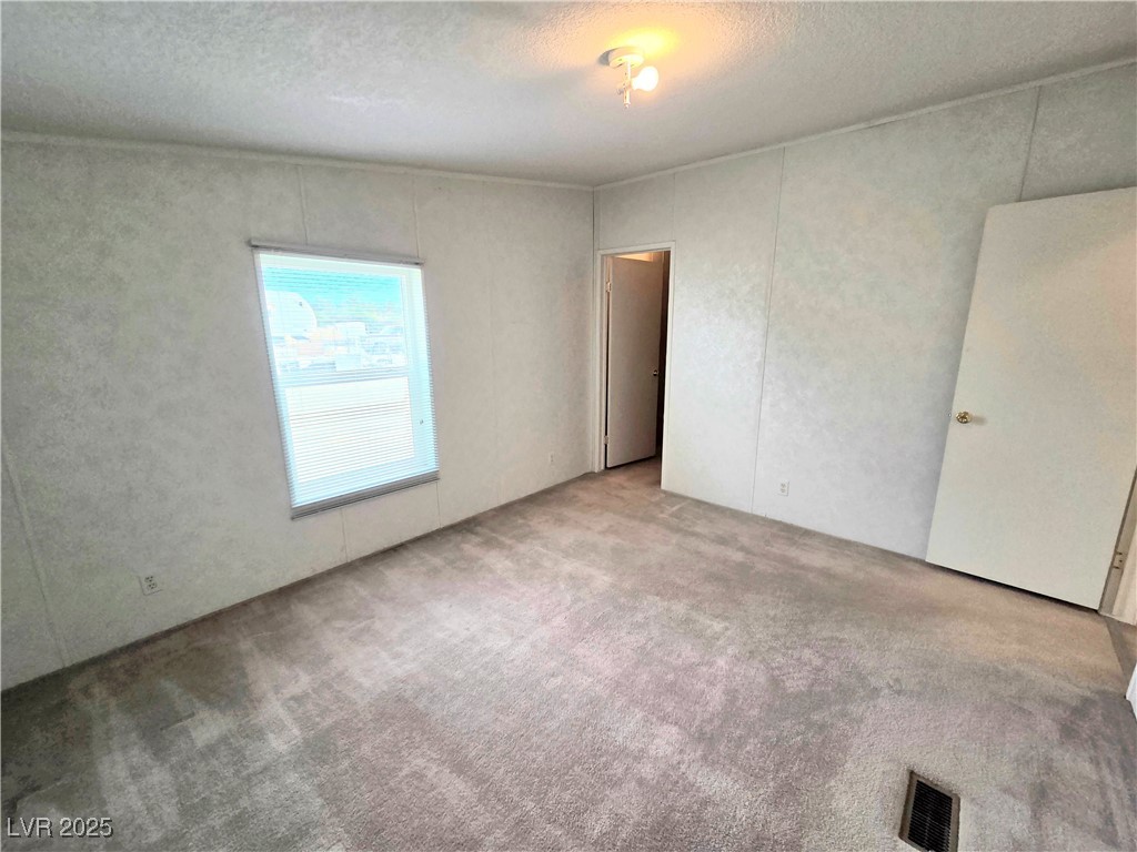 3290 Medicine Man Road Pahrump, NV 89048 - Photo 23 of 27 Spare room with a textured ceiling and carpet floors