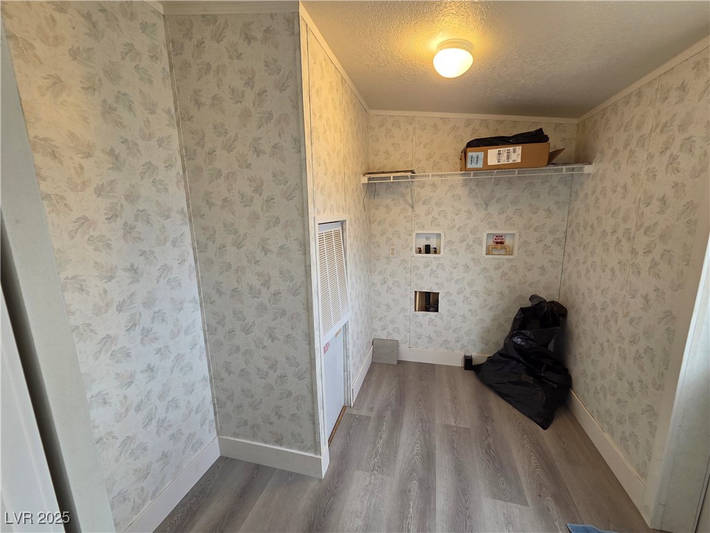 3290 Medicine Man Road Pahrump, NV 89048 - Photo 25 of 27 Laundry room with light wood-style floors, washer hookup, crown molding, a textured ceiling, and wallpapered walls