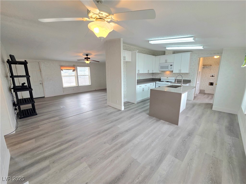 3290 Medicine Man Road Pahrump, NV 89048 - Photo 26 of 27 Kitchen with open floor plan, white cabinets, white appliances, light wood finished floors, and ceiling fan