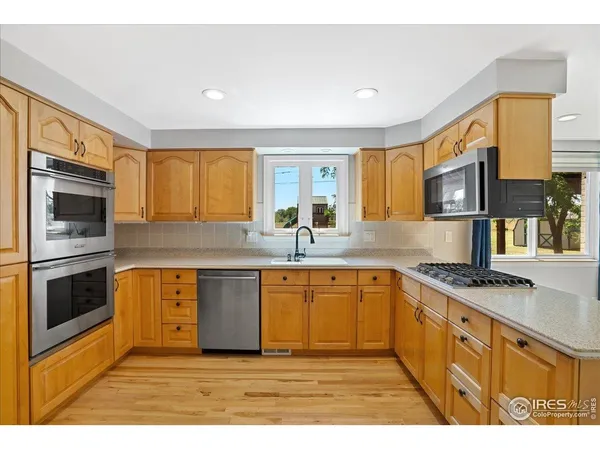 a kitchen with stainless steel appliances granite countertop a stove a sink and a microwave