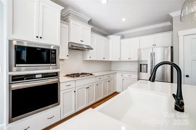 a kitchen with white cabinets stainless steel appliances and sink