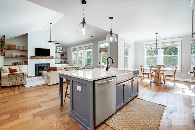 a kitchen with stainless steel appliances granite countertop a sink a stove and a wooden floors
