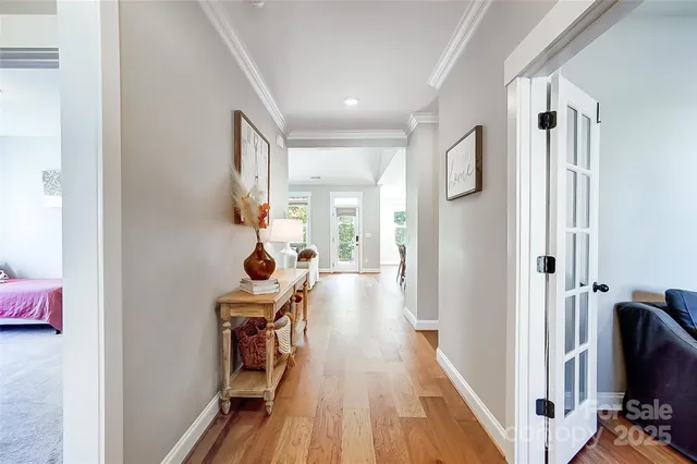 a view of a hallway with wooden floor and furniture