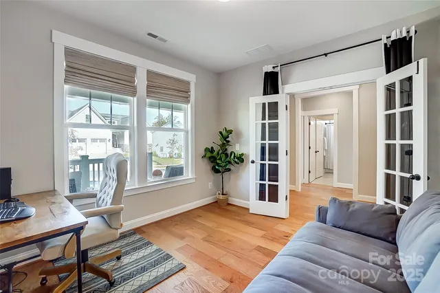 a living room with furniture large window and wooden floor
