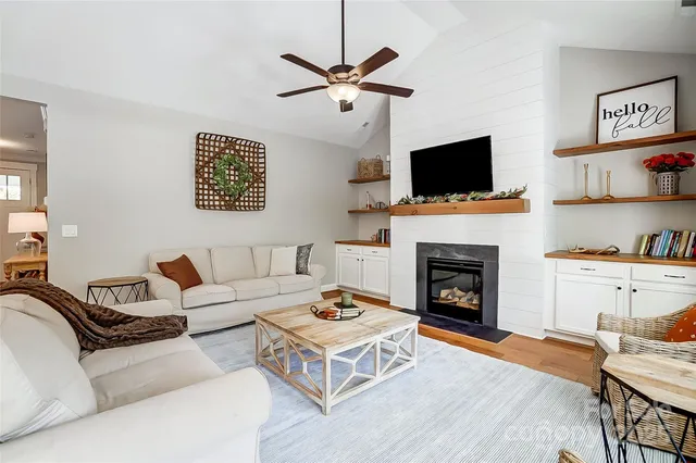 a living room with furniture a flat screen tv and a fireplace