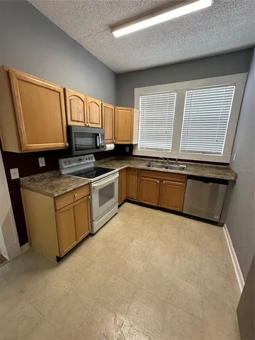 a kitchen with stainless steel appliances granite countertop a stove a sink and a microwave