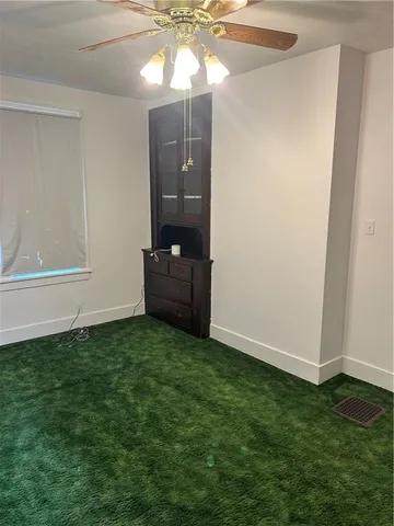 an empty room with a fireplace and fan