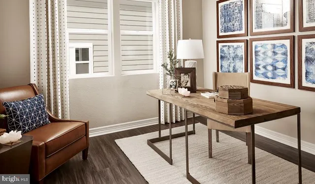 a view of a workspace with furniture and a window