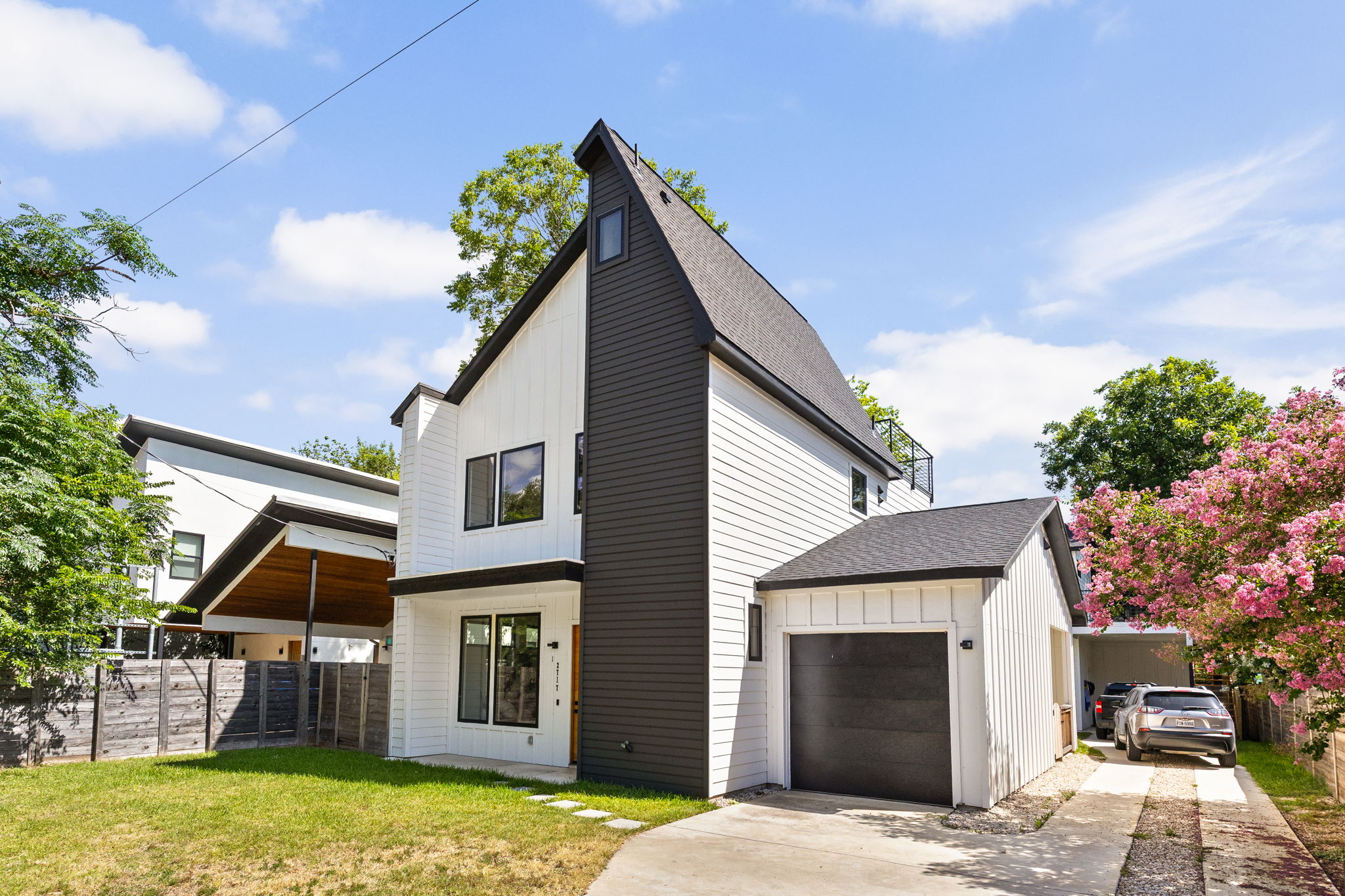 2717 Lyons Road, Unit 1 Austin, TX 78702 - Photo 2 of 40 Modern architecture with a dramatic roofline distinguishes this property, featuring a neat lawn and a blooming tree.