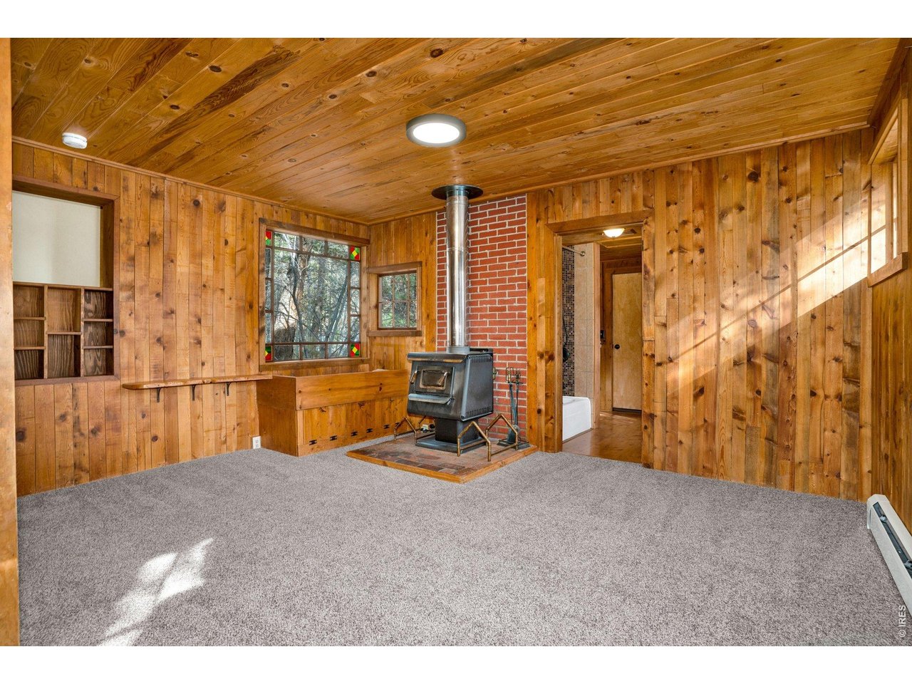 251 Haugen Slide Road Allenspark, CO 80510 - Photo 19 of 42 a bedroom with furniture and large windows