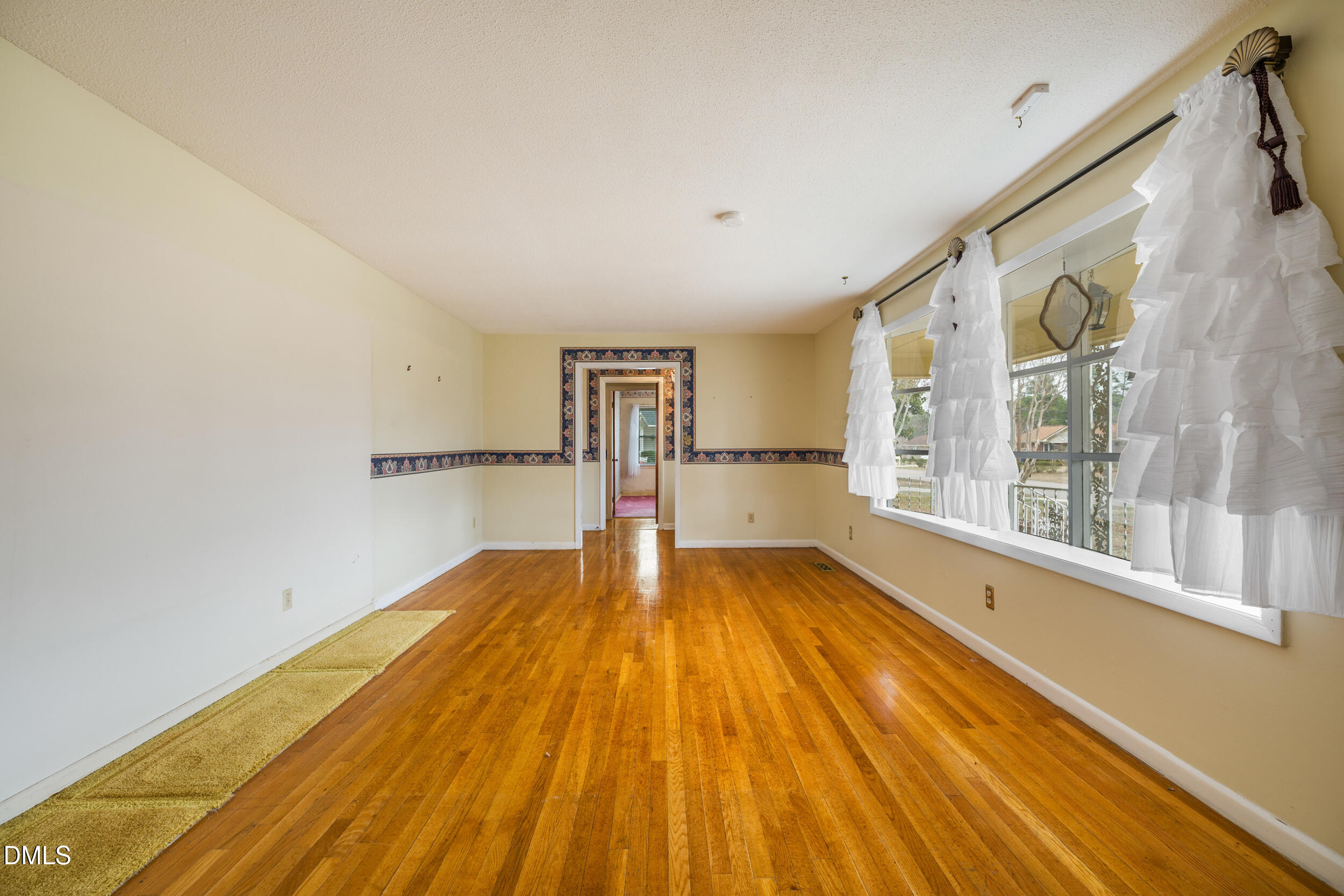 607 Bedford Road Fayetteville, NC 28303 - Photo 11 of 35 a view of empty room with wooden floor and fan