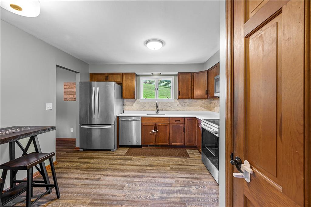 249 Fulton Road Canonsburg, PA 15317 - Photo 6 of 25 a kitchen with stainless steel appliances granite countertop a refrigerator a sink dishwasher a stove with wooden cabinets and floor
