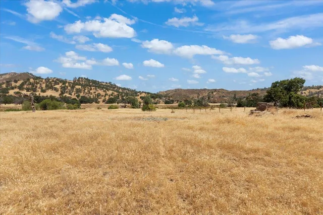 a view of a dry yard with mountains in the background