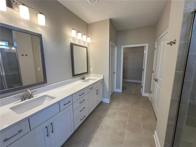 a spacious bathroom with double vanity and mirrors