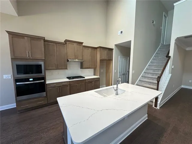 a kitchen with a refrigerator and a stove top oven