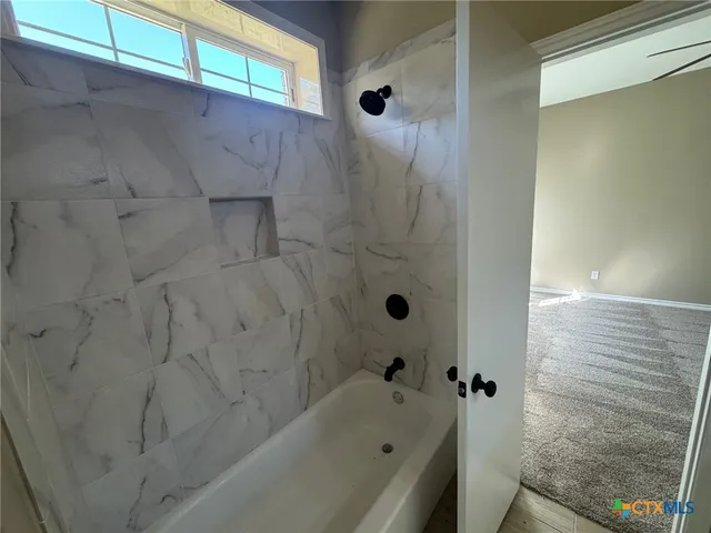 a view of a livingroom with a ceiling fan and window