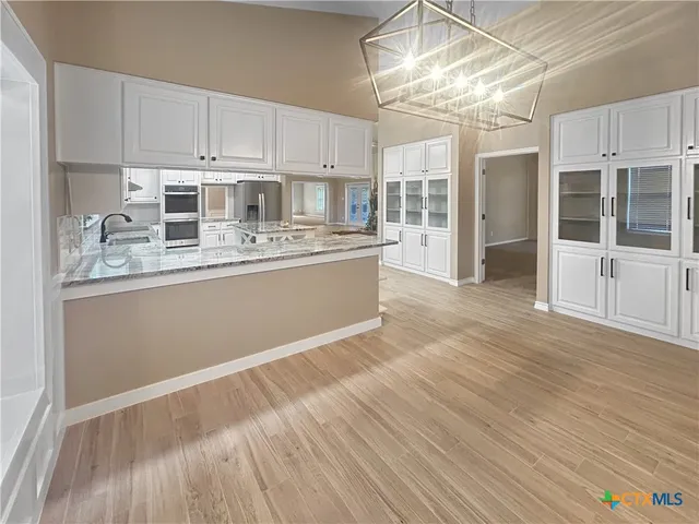 a kitchen with a sink appliances and cabinets