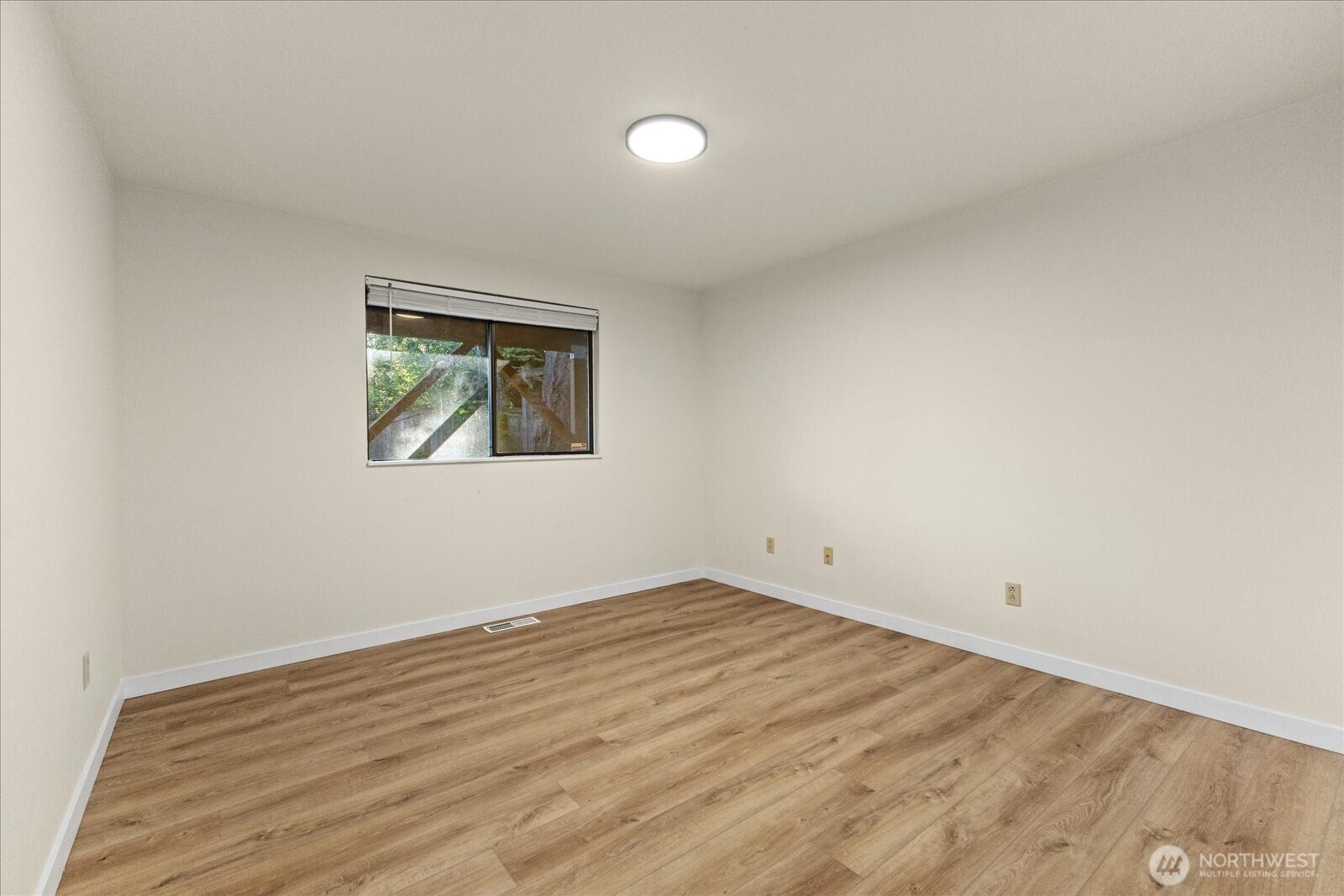 9607 122nd Avenue Southeast Renton, WA 98056 - Photo 13 of 32 wooden floor in an empty room with a window