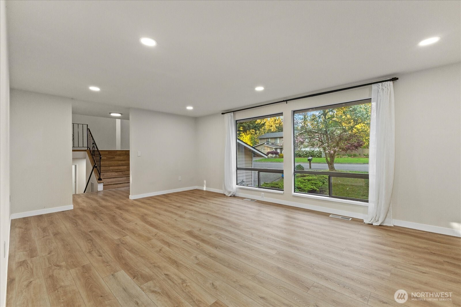 9607 122nd Avenue Southeast Renton, WA 98056 - Photo 18 of 32 a view of an empty room with wooden floor and a window