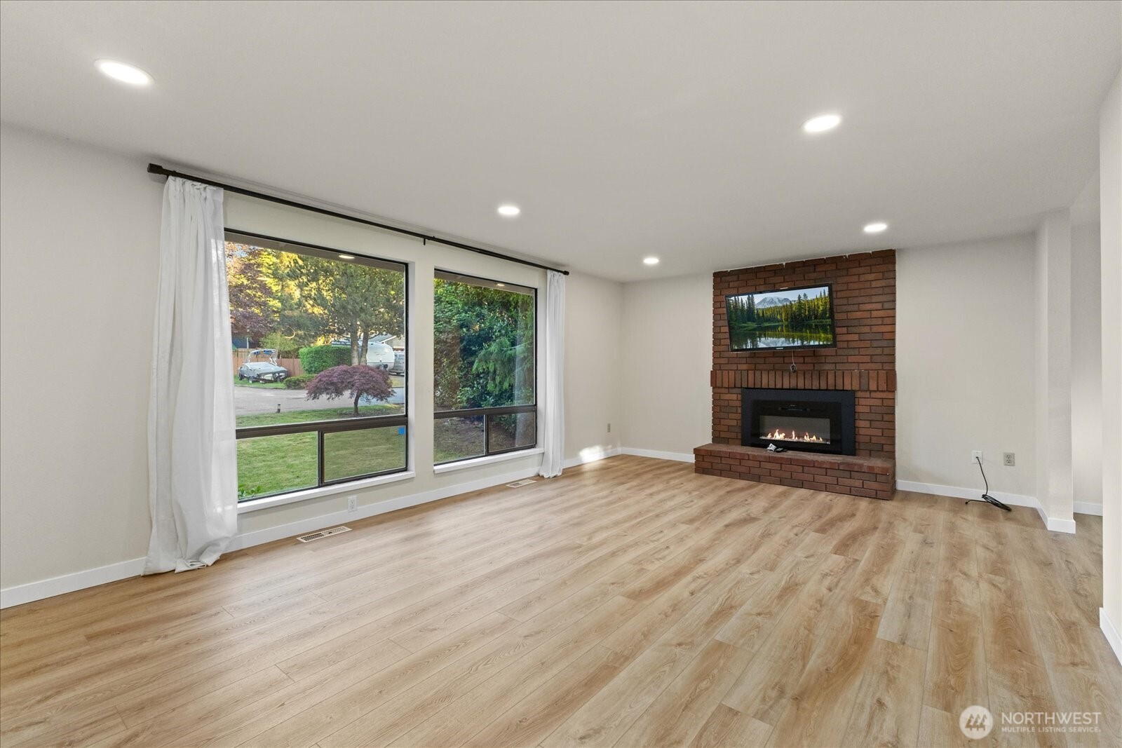 9607 122nd Avenue Southeast Renton, WA 98056 - Photo 5 of 32 a view of an empty room with wooden floor and a window