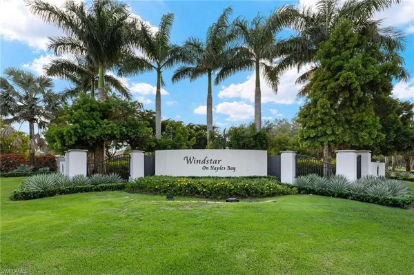 a view of a house with a big yard and palm trees