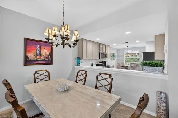 a view of a dining room with furniture a chandelier and wooden floor