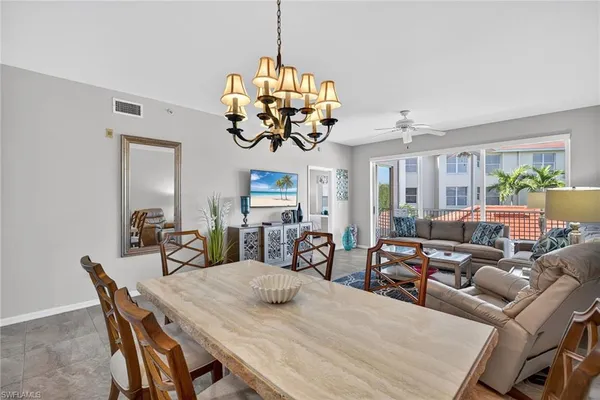 a view of a dining room with furniture a chandelier and wooden floor