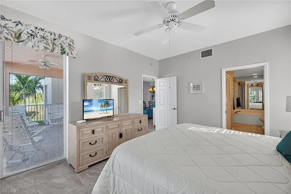 a bedroom with a bed a dresser and next to a window