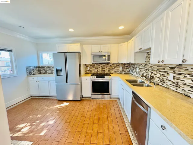 a kitchen with stainless steel appliances granite countertop a stove a sink and a refrigerator