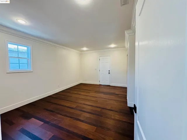 a view of a room with wooden floor and window