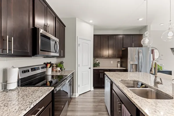 a kitchen with granite countertop stainless steel appliances cabinets a sink and a counter space