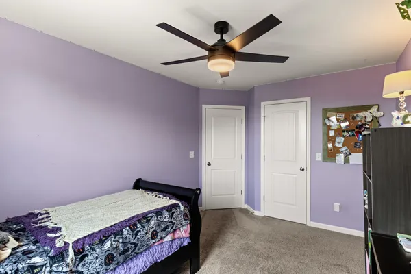 a bed room with a bed and a ceiling fan