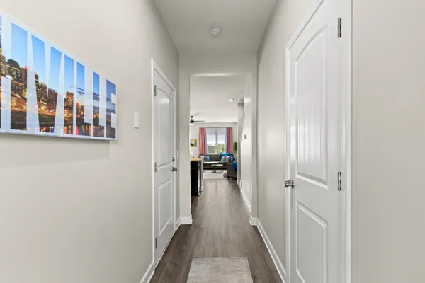 a view of a hallway with a livingroom and a hall with furniture