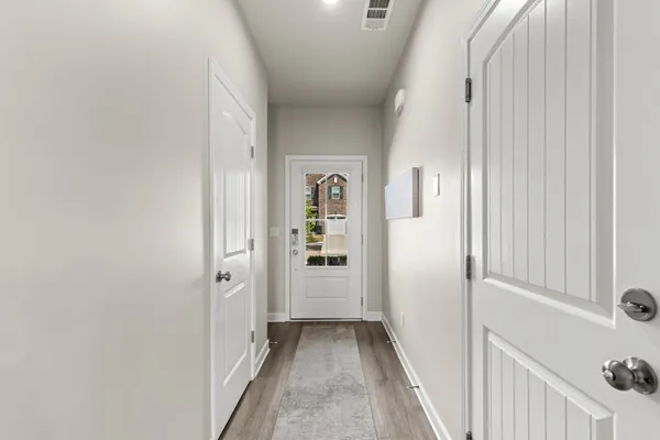 a view of a hallway with wooden floor and windows