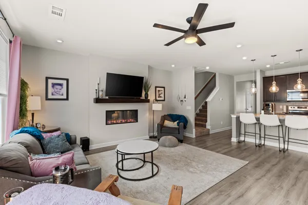 a living room with furniture a flat screen tv and a table