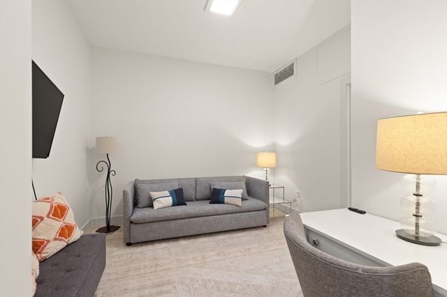 a living room with furniture and a lamp