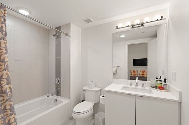 a bathroom with a bathtub sink mirror and toilet