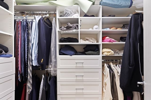 a view of walk in closet with clothes and shoes
