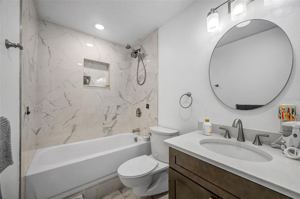 7149 Spruce Drive Weeki Wachee, FL 34607 - Photo 13 of 23 a bathroom with a granite countertop toilet a sink and a mirror