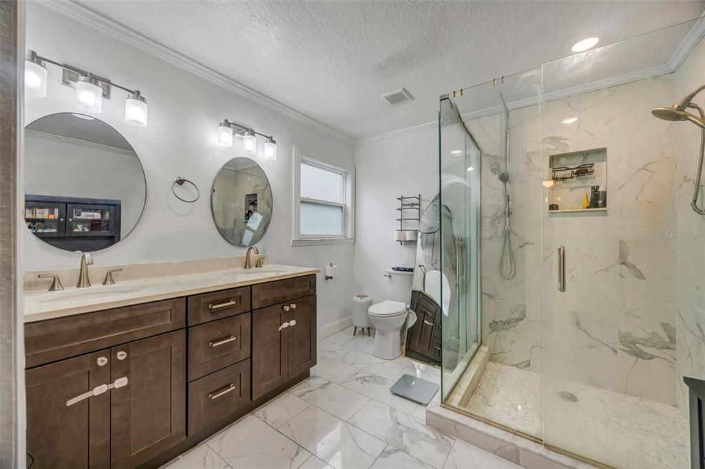 7149 Spruce Drive Weeki Wachee, FL 34607 - Photo 9 of 23 a spacious bathroom with a double vanity sink toilet mirror and bathtub