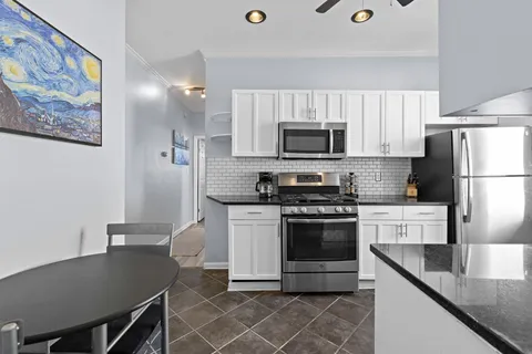 a kitchen with stainless steel appliances granite countertop a stove a sink dishwasher a refrigerator and a microwave