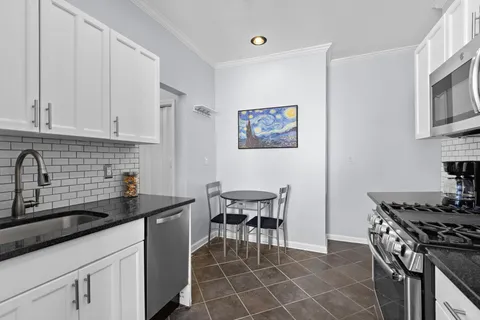 a kitchen with stainless steel appliances a stove a sink a counter space and cabinets