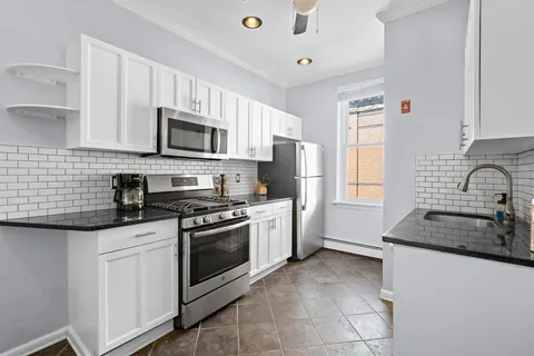 a kitchen with granite countertop a sink stainless steel appliances and cabinets