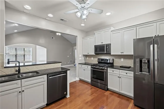 a kitchen with a sink stainless steel appliances and white cabinets