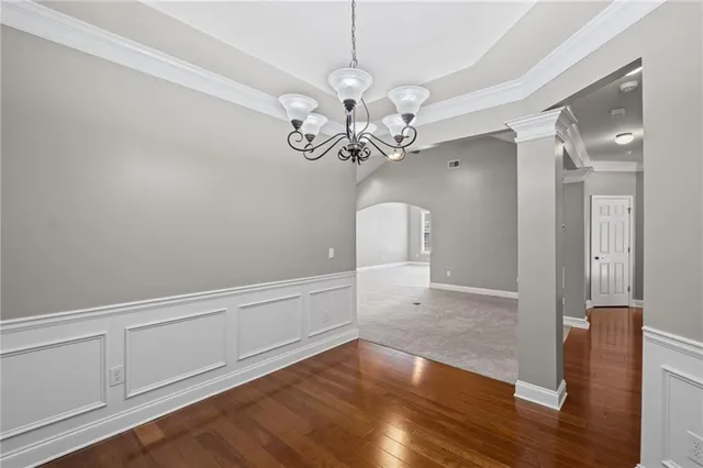 a view of a hallway with wooden floor and chandelier