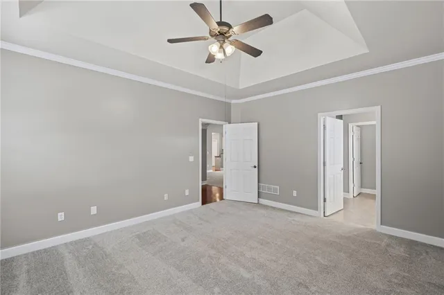 an empty room with closet and a ceiling fan