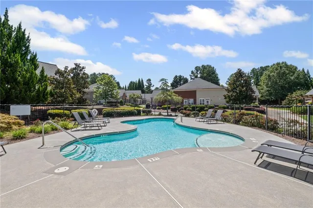 a view of a swimming pool with a patio and a garden