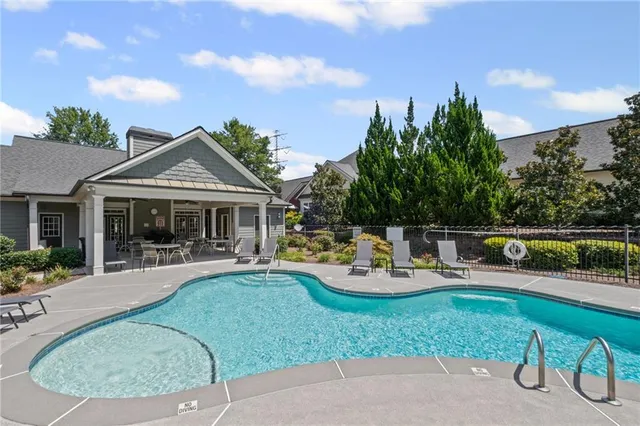 a view of a house with backyard sitting area and swimming pool