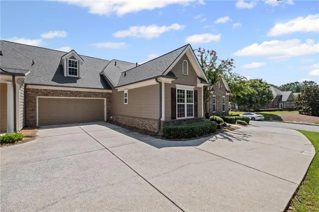 a view of a white house with a yard and potted plants